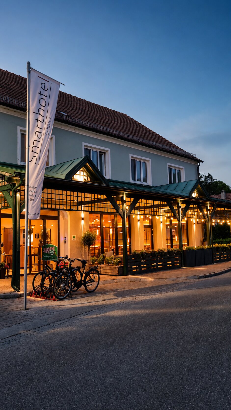 Smarthotel Schmid – Abendstimmung Smarthotel Schmid in Sitzenberg-Reidling bei Abendstimmung mit beleuchteter Terrasse
